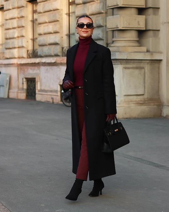 Black coat over burgundy turtleneck and trousers